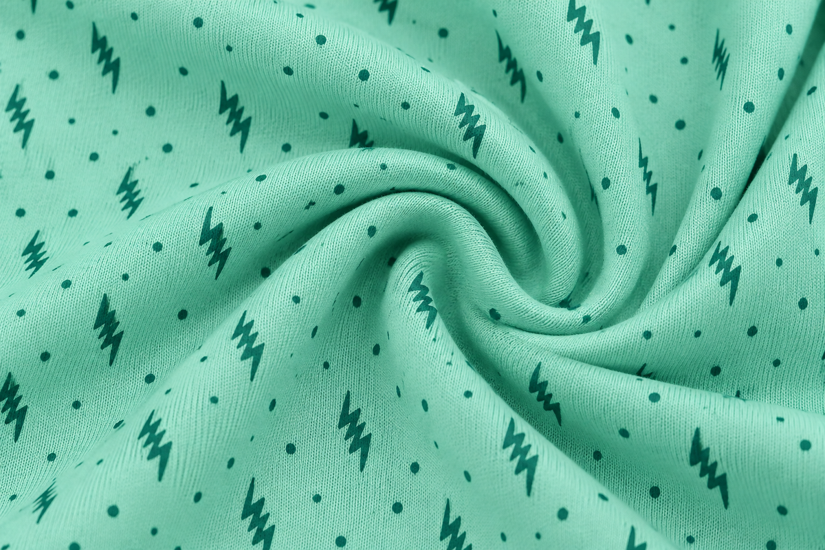 Mint women’s stretch-knit pajama set — solid long-sleeve top and printed trousers, zigzag-and-dot knit fabric close-up